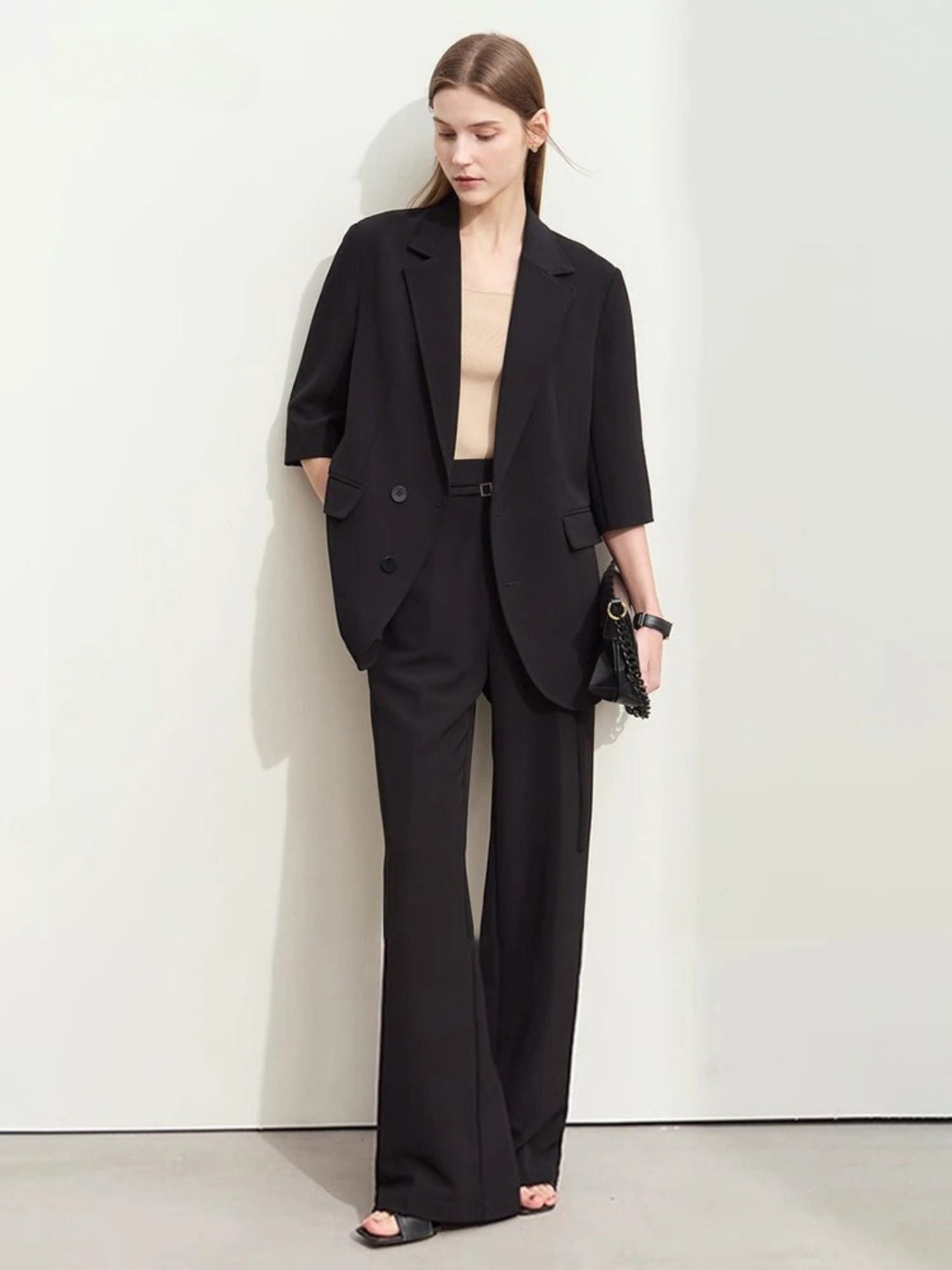 Schwarzer Damen-Hosenanzug mit weitem Blazer, Modell frontal stehend.
