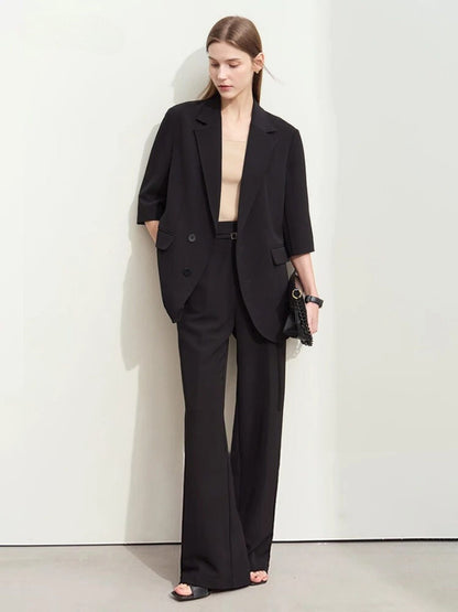 Schwarzer Damen-Hosenanzug mit weitem Blazer, Modell frontal stehend.