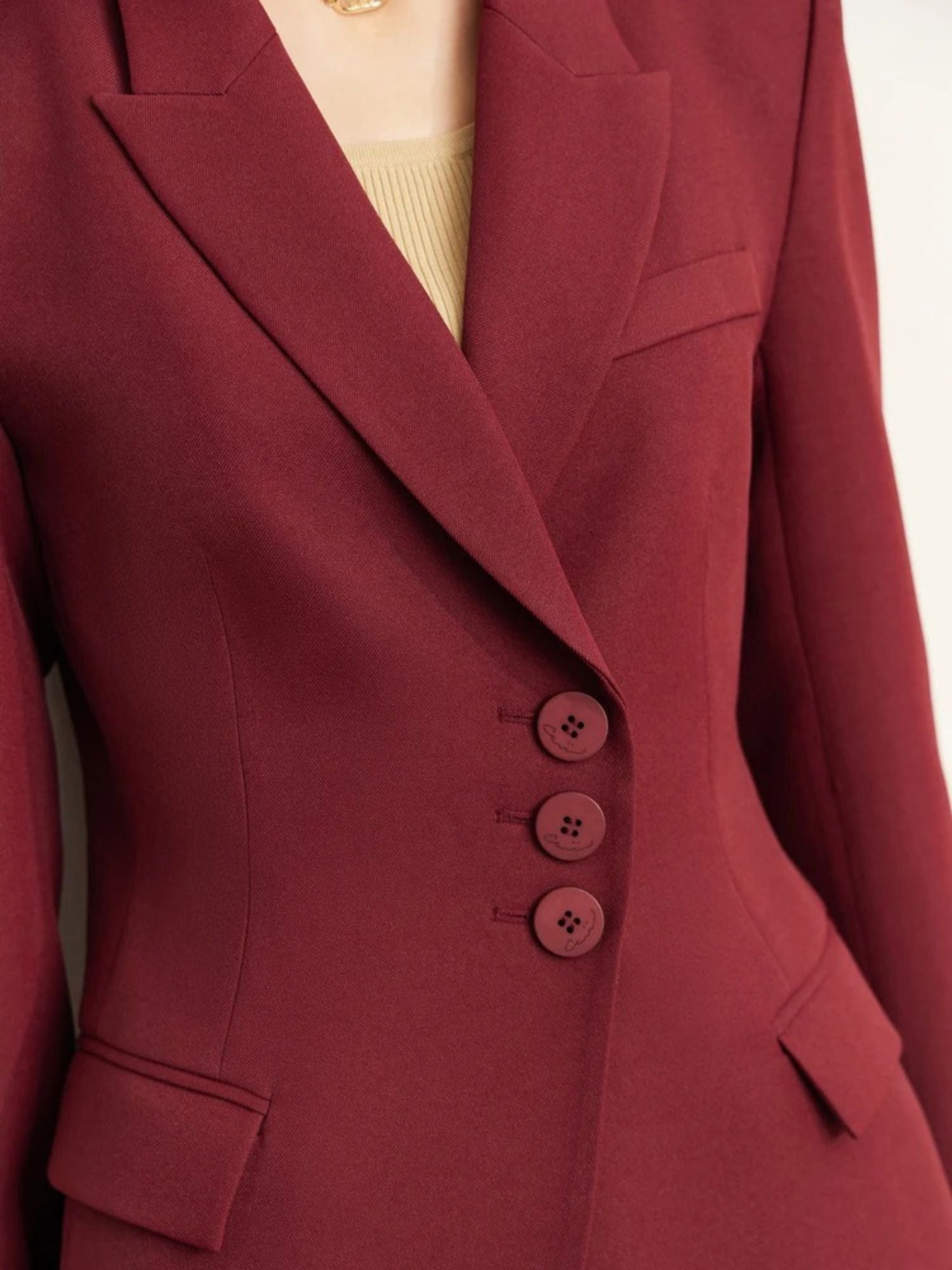 Detailaufnahme: Knopfleiste des dunkelroten Blazers.