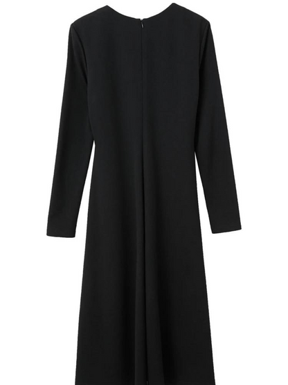 The back side of a dress that has long, fitted sleeves and an a-line silhouette.