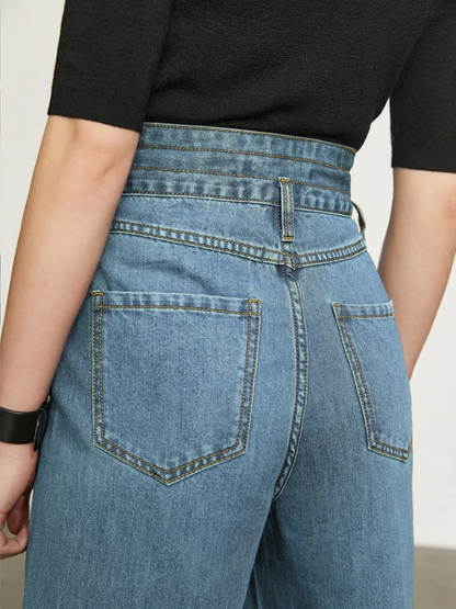 A close up of the backside of a pair of jeans showcasing the cinched waist design and back pockets.
